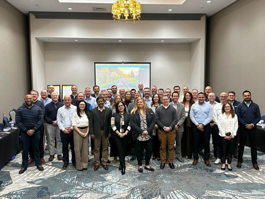 Odyssey employees gathered together at a leadership team meeting.